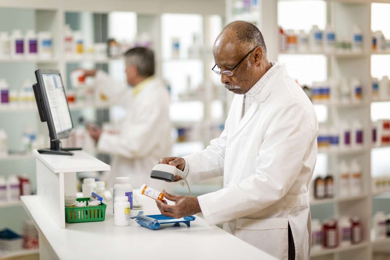 Pharmacist Checking Prescription pharmacist scans pill bottles at a pharmacy
