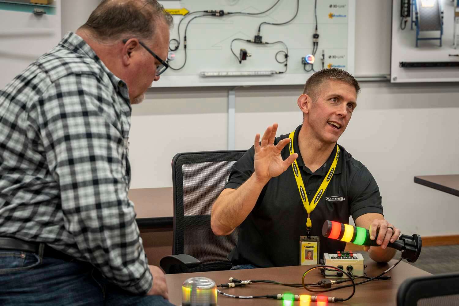 Man explaining how a Banner tower light works to a group of distributors